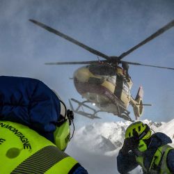 Miembros del equipo de rescate de montaña CRS Alpes Grenoble se preparan para abordar un helicóptero de la Securité Civile (gestión de emergencias) tras una misión de rescate de emergencia por avalancha en una zona fuera de pista del macizo de Écrins, en los Alpes franceses. | Foto:JEFF PACHOUD / AFP