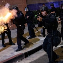 Un agente del Departamento de Policía de Los Ángeles dispara una munición no letal mientras se enfrenta a manifestantes durante una protesta contra el Servicio de Inmigración y Control de Aduanas (ICE) de Estados Unidos en Los Ángeles. El jefe de fronteras de Donald Trump declaró que algunos agentes federales podrían ser retirados de Minneapolis, la ciudad del norte de Estados Unidos que se ha convertido en el punto álgido de la ofensiva migratoria del presidente. La administración Trump, ante la crítica pública por la muerte a tiros de dos estadounidenses a manos de agentes federales en Minneapolis, también flexibilizó las operaciones migratorias en el estado nororiental de Maine. | Foto:ETIENNE LAURENT / AFP