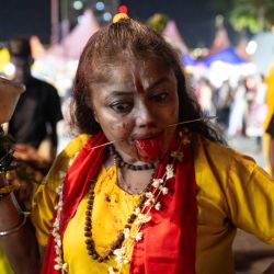 Un devoto hindú en estado de trance reacciona antes de subir los 272 escalones del templo de las Cuevas de Batu para realizar ofrendas durante el festival Thaipusam, en las Cuevas de Batu, a las afueras de Kuala Lumpur. Cientos de miles de malayos de origen indio se reunieron en templos de todo el país para celebrar el festival religioso Thaipusam y muchos se perforaron el cuerpo con ganchos y brochetas en señal de devoción. | Foto:Mohd Rasfan / AFP