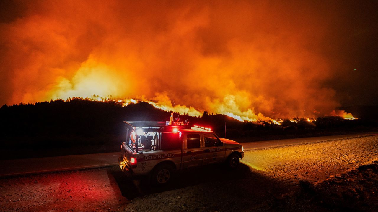 Bomberos viajan en un vehículo por una carretera junto a un incendio forestal en las montañas de la zona rural de Epuyén, en la región patagónica de la provincia de Chubut, Argentina. El gobierno argentino declaró emergencia en la Patagonia, donde los incendios forestales han arrasado vastas extensiones de bosque desde el inicio del verano austral. | Foto:GONZALO KEOGAN / AFP