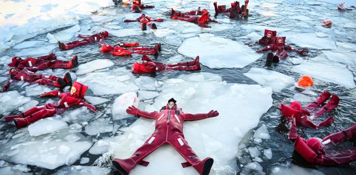 Participantes con trajes isotérmicos flotan entre témpanos de hielo en un agujero en el río Moscova congelado, disfrutando de la creciente tendencia de relajación, en Moscú, Rusia.