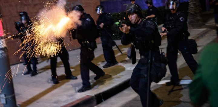 Un agente del Departamento de Policía de Los Ángeles dispara una munición no letal mientras se enfrenta a manifestantes durante una protesta contra el Servicio de Inmigración y Control de Aduanas (ICE) de Estados Unidos en Los Ángeles. El jefe de fronteras de Donald Trump declaró que algunos agentes federales podrían ser retirados de Minneapolis, la ciudad del norte de Estados Unidos que se ha convertido en el punto álgido de la ofensiva migratoria del presidente. La administración Trump, ante la crítica pública por la muerte a tiros de dos estadounidenses a manos de agentes federales en Minneapolis, también flexibilizó las operaciones migratorias en el estado nororiental de Maine.