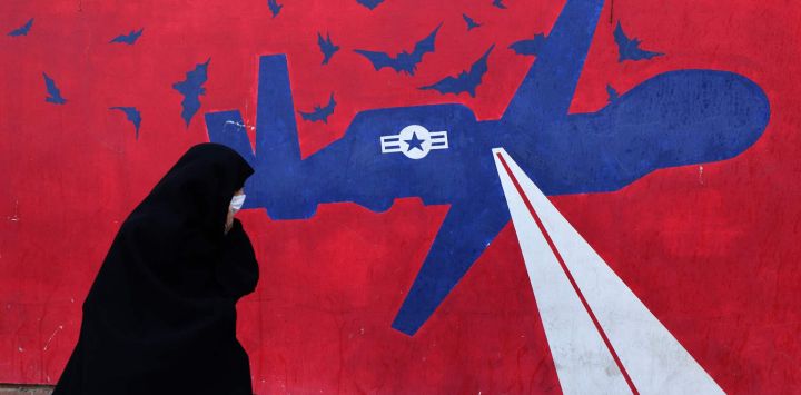 Una mujer pasa junto a un mural que representa un dron estadounidense, pintado en los muros exteriores de la antigua embajada estadounidense en Teherán, conocida popularmente como la "Guarida del Espionaje". El líder supremo de Irán, el ayatolá Alí Jamenei, advirtió de una "guerra regional" si Estados Unidos atacaba tras los intensos despliegues militares de Washington en el Golfo.