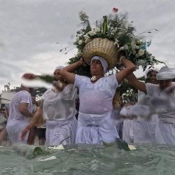 Los fieles participan en la ceremonia tradicional de Iemanjá, la diosa del mar de la religión sincrética afrobrasileña Umbanda, en la playa de Arpoador en Río de Janeiro, Brasil. | Foto:MAURO PIMENTEL / AFP