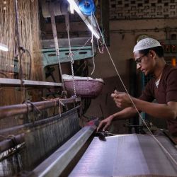 Un trabajador teje saris y telas para vestidos en telares mecánicos en un taller de Varanasi. India invertirá una cifra récord de 133 000 millones de dólares en infraestructura, según reveló la ministra de finanzas en su discurso sobre el presupuesto nacional, con planes para nuevas conexiones ferroviarias de alta velocidad e inversiones en tecnología. El país más poblado del mundo considera que una inversión masiva en infraestructura es clave para mantener su alta tasa de crecimiento, impulsando la manufactura nacional y creando millones de nuevos empleos. | Foto:NIHARIKA KULKARNI / AFP