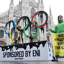 Activistas de Greenpeace se manifiestan contra el patrocinio del gigante italiano del petróleo y el gas, Eni, a los Juegos Olímpicos de Milán Cortina 2026 en la Piazza Duomo de Milán, Italia. | Foto:Wang Zhao / AFP