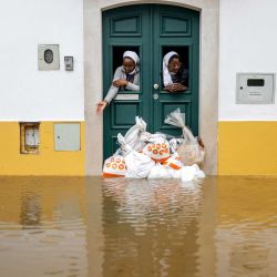 Dos monjas observan desde una puerta protegida con sacos de arena mientras las aguas del río Sado cubren la calle en Alcácer do Sal, al sur de Portugal, durante la tormenta Leonardo. Una tormenta que desató hasta 35 centímetros (14 pulgadas) de lluvia en 24 horas azotó la Península Ibérica, obligando a miles de personas en el sur de España a abandonar sus hogares, cerrando escuelas y cancelando trenes. Leonardo agravó las dificultades de los residentes en Portugal, que ya se estaban recuperando de la tormenta Kristin de la semana pasada, que causó cinco muertos, cientos de heridos y dejó sin electricidad a decenas de miles de clientes. | Foto:PATRICIA DE MELO MOREIRA / AFP
