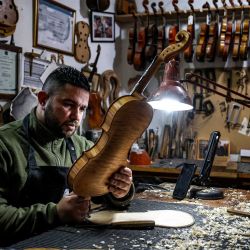El luthier palestino Shehada Shalalda ensambla un violín en su taller de Ramallah, Cisjordania ocupada. | Foto:ZAIN JAAFAR / AFP