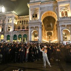 La bailarina italiana Nicoletta Manni (centro) lleva la llama olímpica a su llegada a la Piazza Duomo antes de la inauguración de los Juegos Olímpicos de Invierno Milano Cortina 2026 en Milán, Italia. | Foto:PIERO CRUCIATTI / AFP