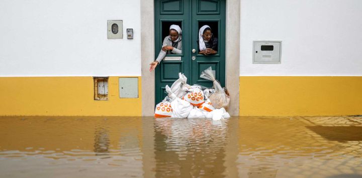Dos monjas observan desde una puerta protegida con sacos de arena mientras las aguas del río Sado cubren la calle en Alcácer do Sal, al sur de Portugal, durante la tormenta Leonardo. Una tormenta que desató hasta 35 centímetros (14 pulgadas) de lluvia en 24 horas azotó la Península Ibérica, obligando a miles de personas en el sur de España a abandonar sus hogares, cerrando escuelas y cancelando trenes. Leonardo agravó las dificultades de los residentes en Portugal, que ya se estaban recuperando de la tormenta Kristin de la semana pasada, que causó cinco muertos, cientos de heridos y dejó sin electricidad a decenas de miles de clientes.