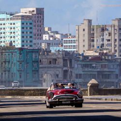 Turistas viajan en un antiguo coche estadounidense usado como taxi por una tranquila avenida en La Habana. Foto de ADALBERTO ROQUE / AFP | Foto:AFP