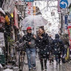 Personas caminan por la zona de Nakano durante una nevada en Tokio. Foto de Yuichi YAMAZAKI / AFP | Foto:AFP