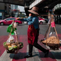 Un vendedor de cacahuetes cruza una carretera en Bangkok. Foto de Anthony WALLACE / AFP | Foto:AFP