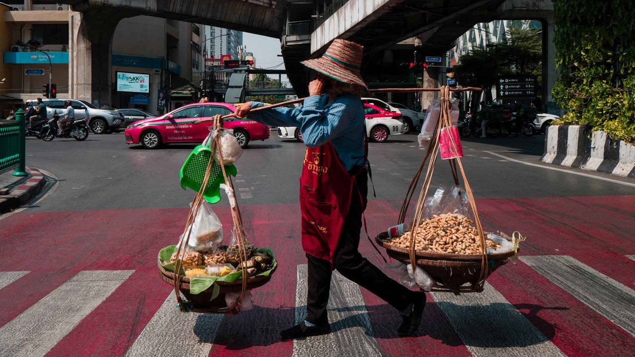 Un vendedor de cacahuetes cruza una carretera en Bangkok. Foto de Anthony WALLACE / AFP | Foto:AFP