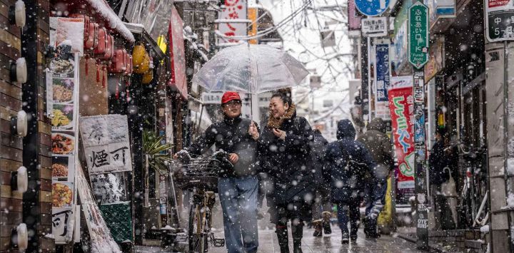 Personas caminan por la zona de Nakano durante una nevada en Tokio. Foto de Yuichi YAMAZAKI / AFP