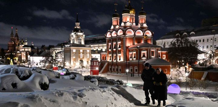 Personas caminan por el parque Zaryadye durante una fría noche de invierno en el centro de Moscú. Foto de HECTOR RETAMAL / AFP