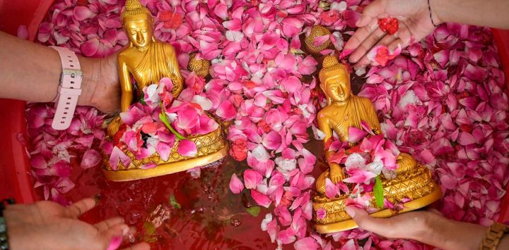 La gente limpia estatuas de Buda en preparación para el Año Nuevo Lunar del Caballo en el Vihara Buddhayana en Surabaya. Foto de JUNI KRISWANTO / AFP