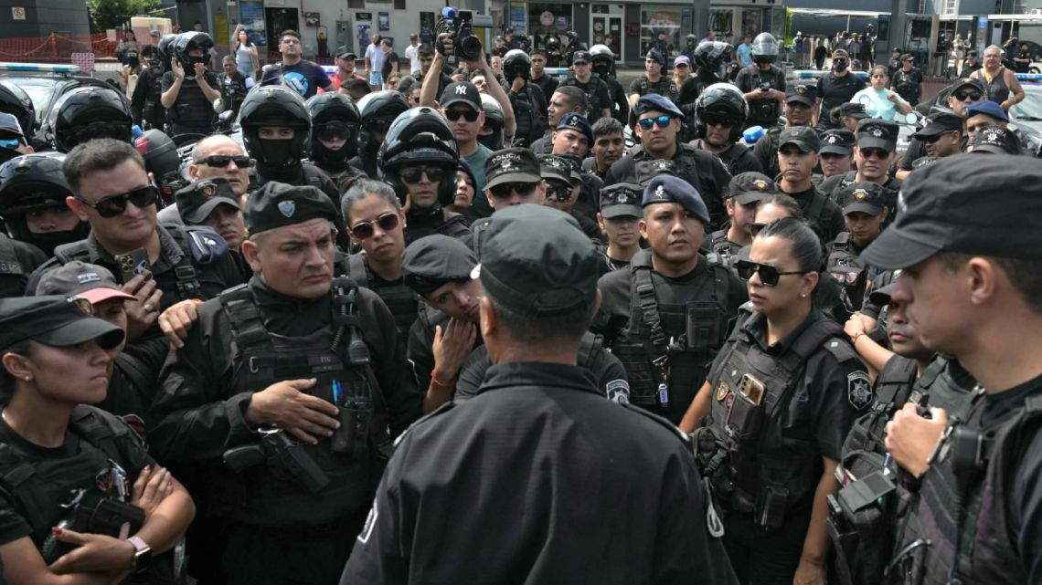 Santa Fe Province police chief Luis Maldonado speaks with police officers taking part in a protest outside the force's headquarters during a demonstration demanding higher salaries and improved mental health support amid growing pressure from long…