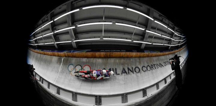 Devin Wardrope de Canadá y Cole Zajanski de Canadá compiten en la primera carrera de dobles masculinos de luge en el Centro de Deslizamiento de Cortina. Foto de Tiziana FABI / AFP