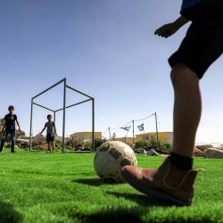 Niños palestinos juegan al fútbol en un campo rodeado de banderas israelíes, después de que el campo recibiera un aviso de demolición por parte de las autoridades israelíes.Foto de HAZEM BADER / AFP | Foto:AFP