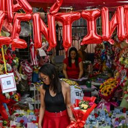 La gente compra flores en un mercado antes del Día de San Valentín en Manila. Foto de Jam STA ROSA / AFP | Foto:AFP
