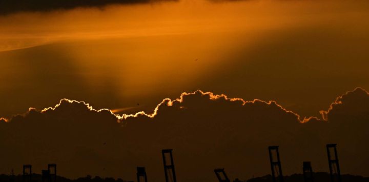 Grúas portuarias en el Puerto de Balboa, CK Hutchison Holdings se ven durante el atardecer en la entrada del Canal de Panamá.Foto de MARTIN BERNETTI / AFP