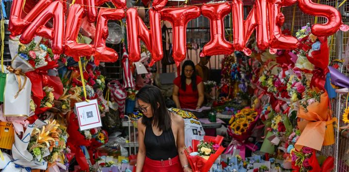 La gente compra flores en un mercado antes del Día de San Valentín en Manila. Foto de Jam STA ROSA / AFP