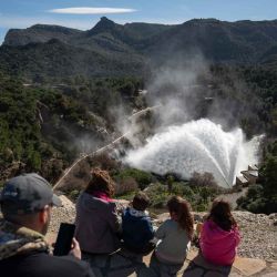 La gente observa el embalse de Guadalteba descargando agua en Campillos, cerca de Málaga, en el sur de España. Foto de JORGE GUERRERO / AFP | Foto:AFP