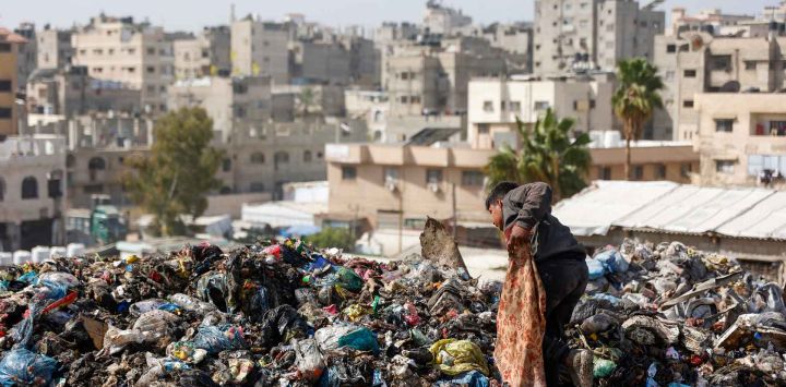 Un joven palestino busca objetos aprovechables en un vertedero en la ciudad de Gaza. Foto de Omar AL-QATTAA / AFP