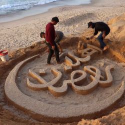 Yazeed Abu Jarad, quien fue desplazado por la guerra de Beit Lahia en el norte de la Franja de Gaza, crea una escultura de arena con el mensaje de saludo "Bienvenido, Ramadán". Foto de Bashar Taleb / AFP | Foto:AFP