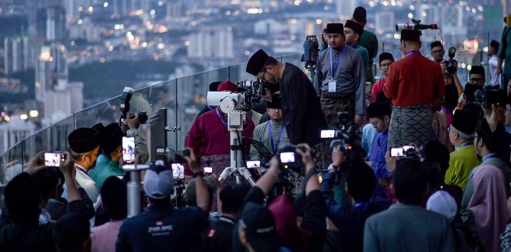 Miembros del departamento religioso de Malasia usan un telescopio para realizar 'Rukyah', la observación de la luna nueva. Foto de Arif KARTONO / AFP