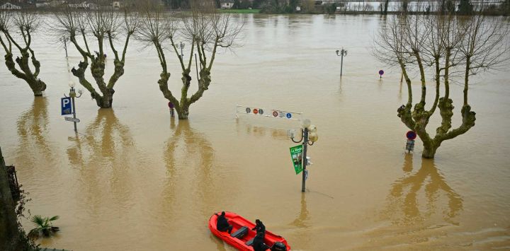 Empleados patrullan en bote cerca del centro de la ciudad inundado por el río Garona en La Reole, en el suroeste de Francia. Foto de Gaizka IROZ / AFP