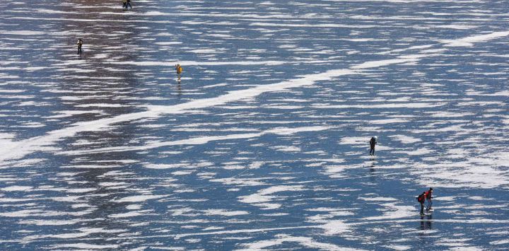 La gente patina sobre hielo en agua congelada cerca del Ayuntamiento de Estocolmo, en el centro de Estocolmo, Suecia. Foto de Jonathan NACKSTRAND / AFP