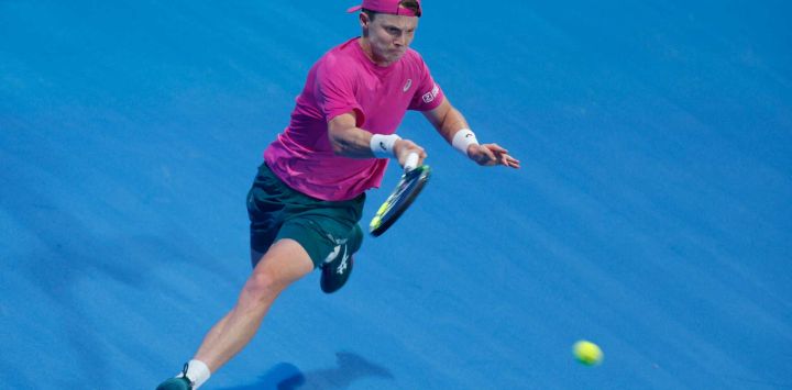 El neerlandés Jesper De Jong devuelve un golpe contra Andrey Rublev de Rusia durante su partido de individuales masculinos en el torneo de tenis Qatar Open. Foto de Karim JAAFAR / AFP