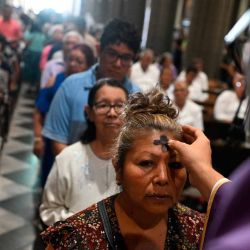 Una mujer recibe la señal de la cruz con ceniza en la frente de un sacerdote durante las celebraciones del Miércoles de Ceniza en la parroquia El Calvario en San Salvador. Foto de Marvin RECINOS / AFP | Foto:AFP