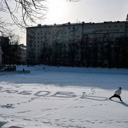 Una mujer escribe la palabra "Amor" en ruso sobre la manta de nieve de los helados Estanques del Patriarca en el centro de Moscú. Foto de Hector RETAMAL / AFP | Foto:AFP