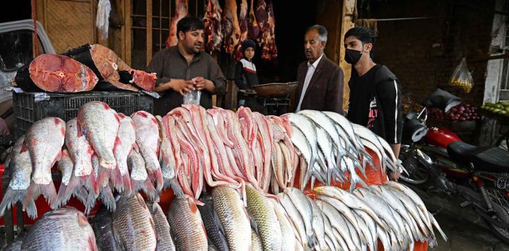 La gente compra pescado y carne de res en una carnicería antes del mes sagrado islámico de ayuno, el Ramadán, en Quetta. Foto de Banaras KHAN / AFP