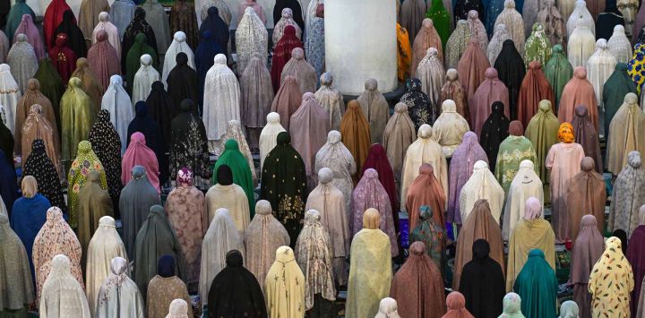 Mujeres musulmanas realizan el Tarawih, las primeras oraciones que marcan el inicio del mes sagrado de ayuno islámico de Ramadán en la mezquita Al Akbar. Foto de JUNI KRISWANTO / AFP