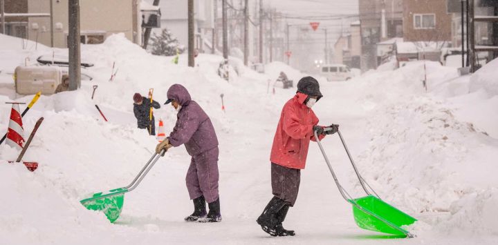 La gente abre caminos en la nieve frente a su casa en Kutchan, prefectura de Hokkaido. Foto de Yuichi YAMAZAKI / AFP
