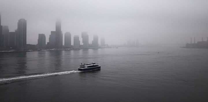 Un transbordador navega por el East River durante un clima con niebla en la ciudad de Nueva York. Foto de CHARLY TRIBALLEAU / AFP