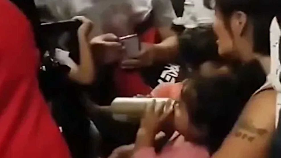 La mujer dándole cerveza a una niña a bordo de un tren 20260219