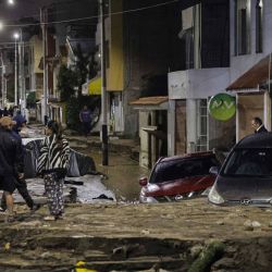 Personas observan junto a autos y casas afectadas por fuertes lluvias en el distrito de Yanahuara, en Arequipa, sur de Perú. Foto de Juan Santy / AFP | Foto:AFP
