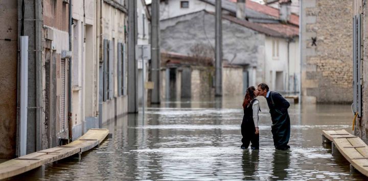 Dos personas se besan en una calle inundada en Cognac, al norte de Burdeos. Foto de ROMAIN PERROCHEAU / AFP