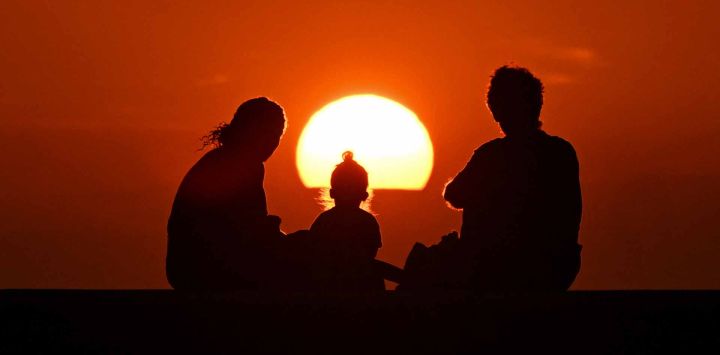 Una familia observa la puesta de sol en La Habana. Foto de Yamil LAGE / AFP