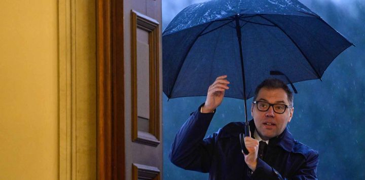 Oleksii Makeiev, embajador de Ucrania en Alemania, se resguarda de la lluvia bajo un paraguas al llegar para reunirse con el presidente alemán Frank-Walter Steinmeier. Foto de John MACDOUGALL / AFP