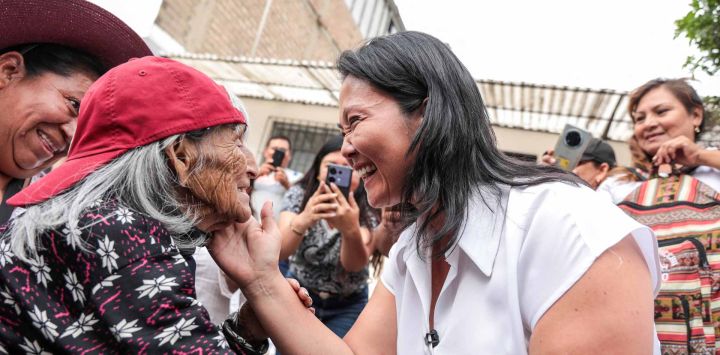 La candidata presidencial peruana del partido Fuerza Popular, Keiko Fujimori (D), saluda a un simpatizante durante un evento de campaña, en Lima. Foto de Connie FRANCE / AFP