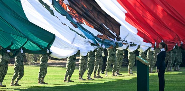 La presidenta de México, Claudia Sheinbaum, rinde homenaje durante la celebración del Día de la Bandera en la Ciudad de México. Foto de YURI CORTEZ / AFP