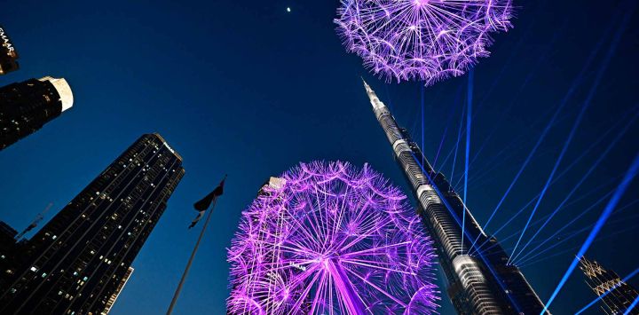 El emblemático rascacielos Burj Khalifa, el edificio más alto del mundo, se ve entre una instalación luminosa en el centro de Dubái. Foto de Giuseppe CACACE / AFP