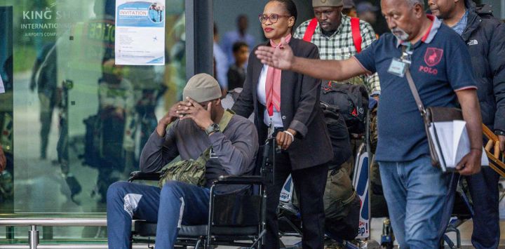 Un grupo de 11 hombres sudafricanos supuestamente atraídos para luchar junto a soldados rusos en la guerra contra Ucrania llega al Aeropuerto Internacional King Shaka en Durban. Foto de RAJESH JANTILAL / AFP