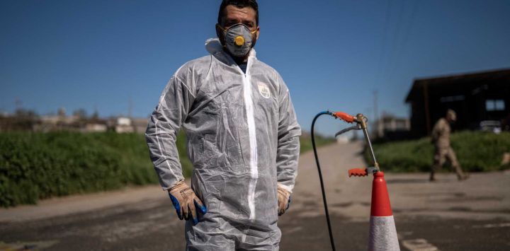 Un trabajador de los Servicios Veterinarios de Chipre espera para rociar desinfectante sobre los vehículos que pasan en una zona afectada por un brote de fiebre aftosa en Aradippou. Foto de JEWEL SAMAD / AFP